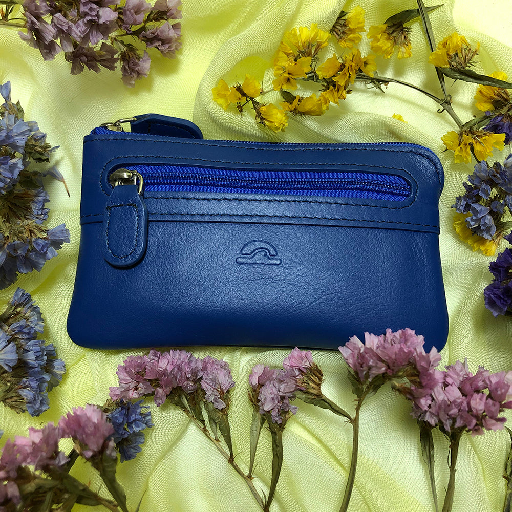Tony Perotti New Rainbow 359 bluette — the blue key pouch photographed on a cloth with dried flowers
