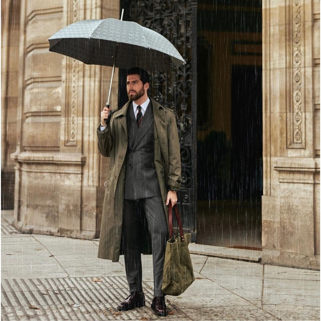 A luxurious gray checkered Pasotti umbrella-cane in a man's hands