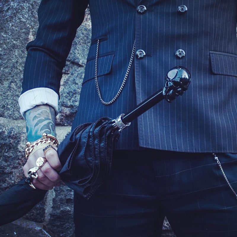 Black Pasotti cane umbrella with a skull in a man's hand