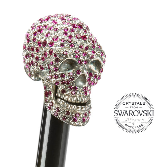 Skull-shaped object with pink and clear gemstones on a white background, featuring Swarovski logo.