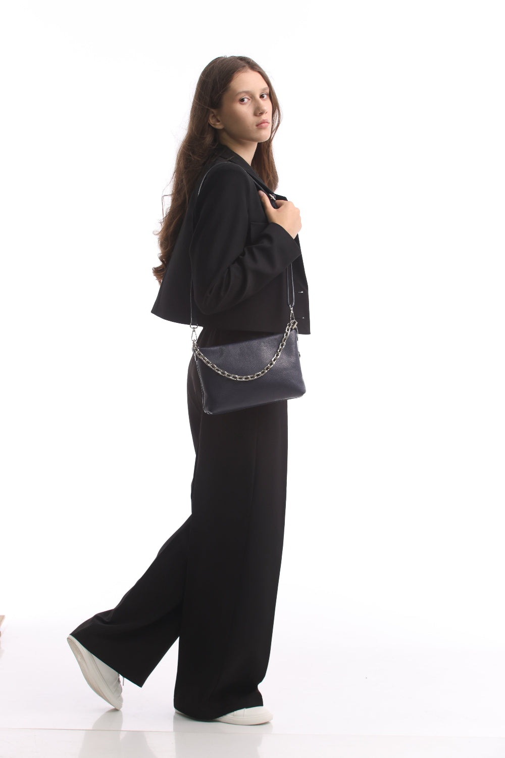 Woman walking with the navy Tony Perotti Borsa CA045-01BL bag on its long leather strap, showing the size of the bag against a full-length figure