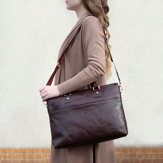 Woman carrying the dark brown Tony Perotti Italico 9625 business bag on the shoulder by its detachable strap