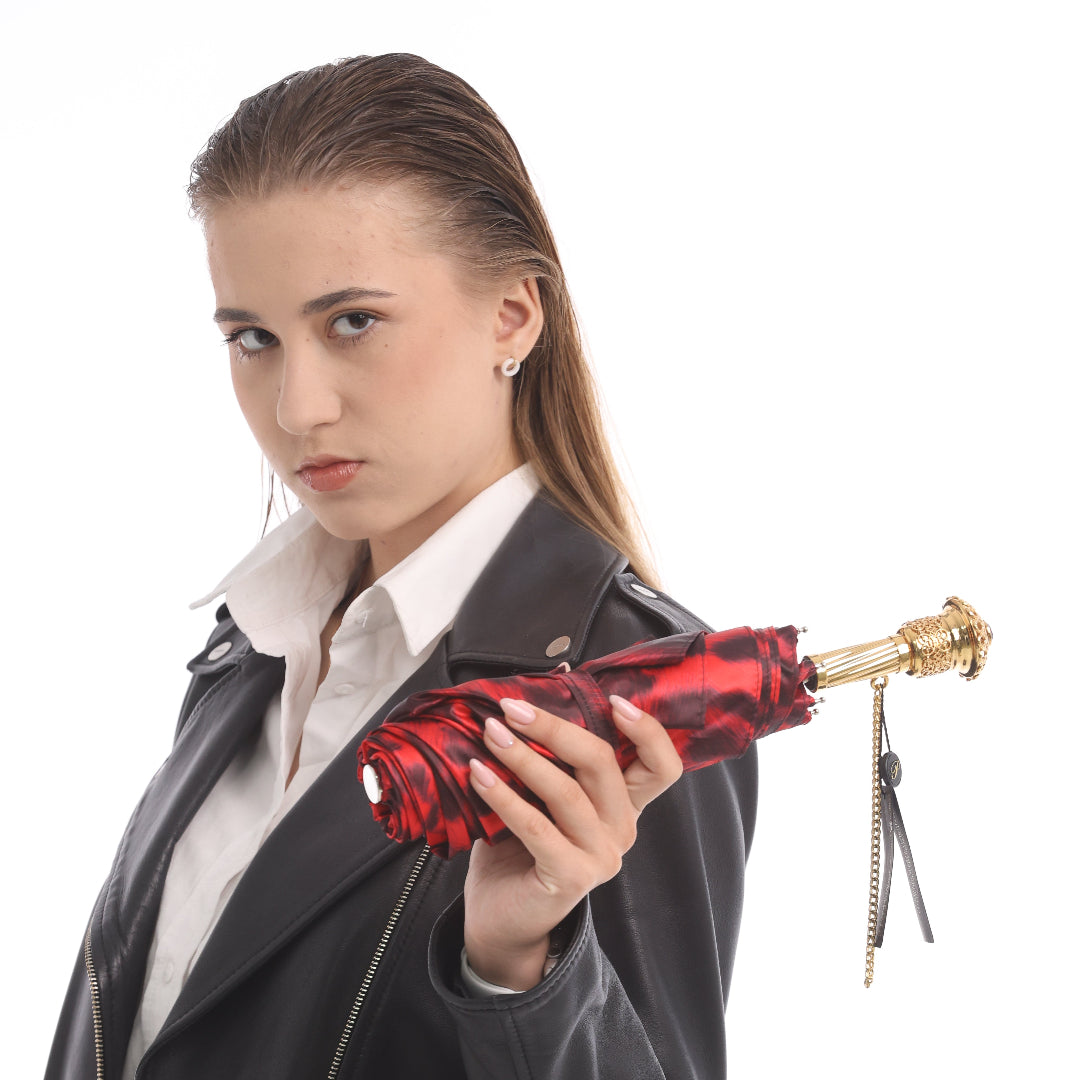 Model holding folded Pasotti leopard print umbrella in hand