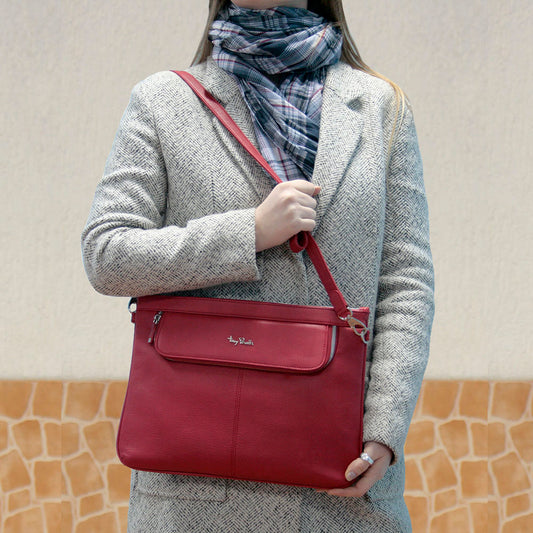 Red leather portfolio Tony Perotti Contatto 9708 rosso worn on the shoulder with a herringbone coat