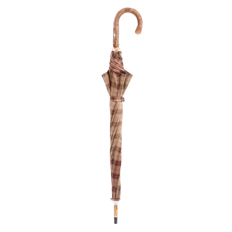 Closed check umbrella standing upright with ash crook handle