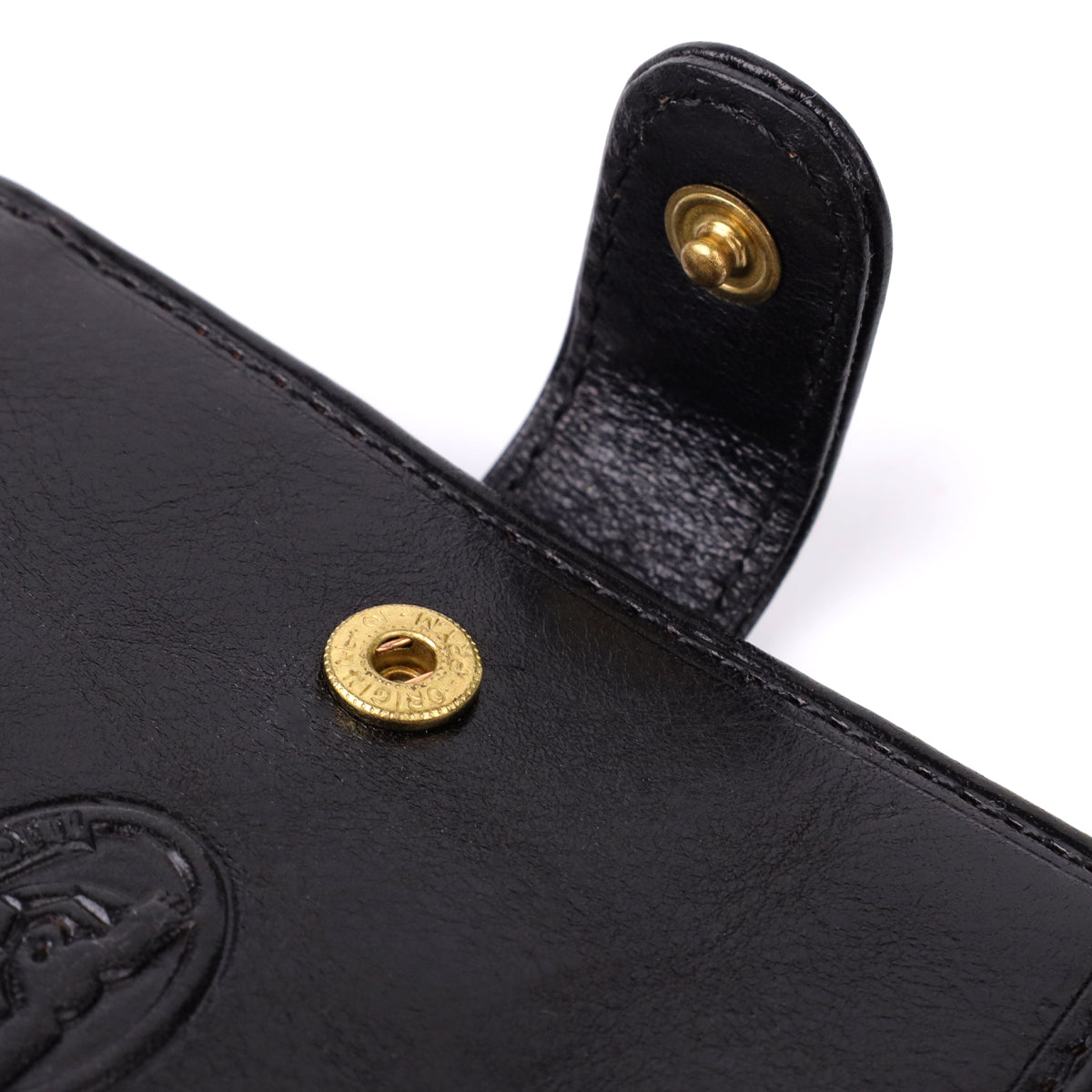 Macro close-up of the snap-strap closure on the Tony Perotti Italico 1256 nero wallet, gold-tone snap stud