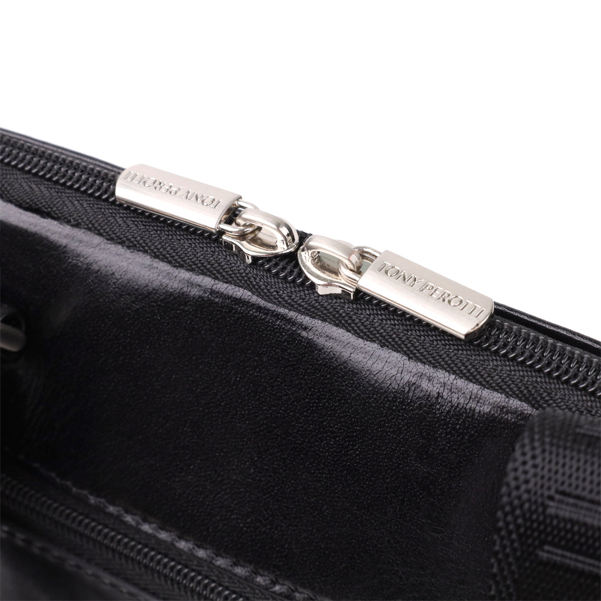 Macro shot of the two zip pullers on the Italico 9137-20 bag, each stamped TONY PEROTTI