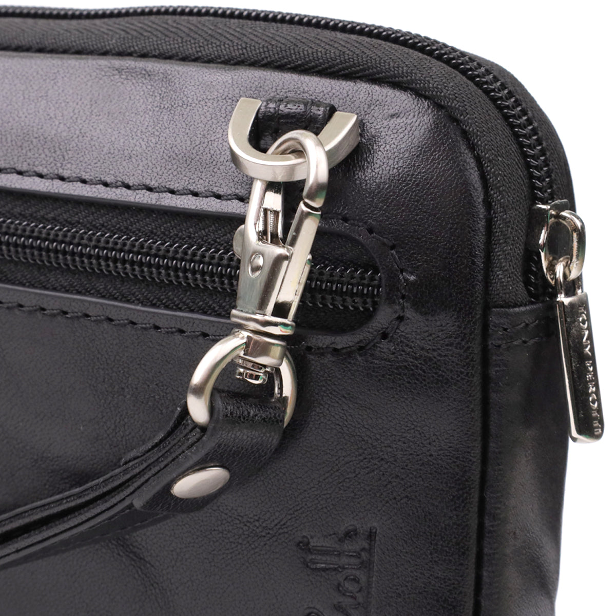 Tony Perotti Italico 9405 nero black leather clutch opened fully on its zip — checked lining and the hologram authenticity tag between the two sections