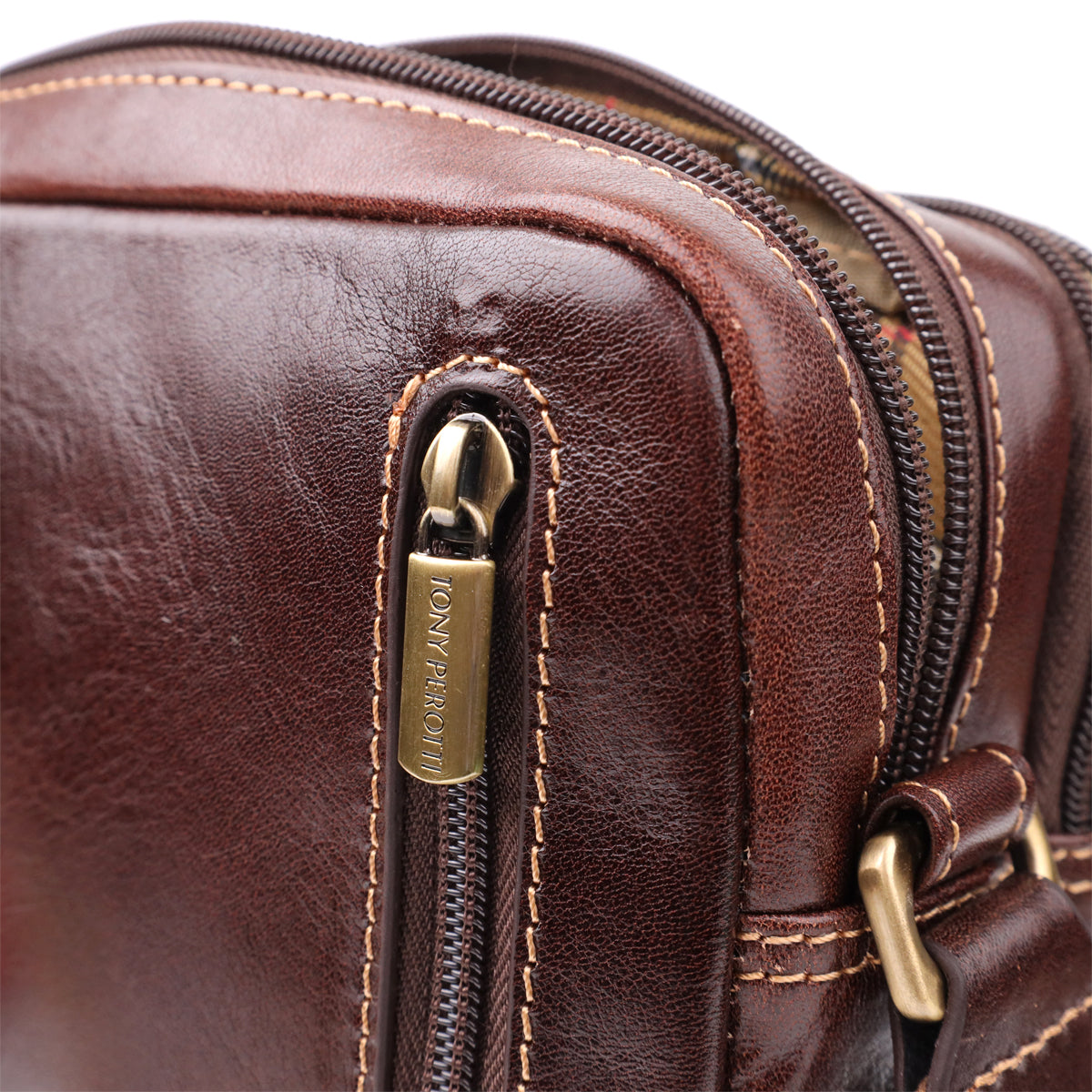 Macro shot of the main compartment zip puller on the Italico 9148-17 bag, stamped TONY PEROTTI