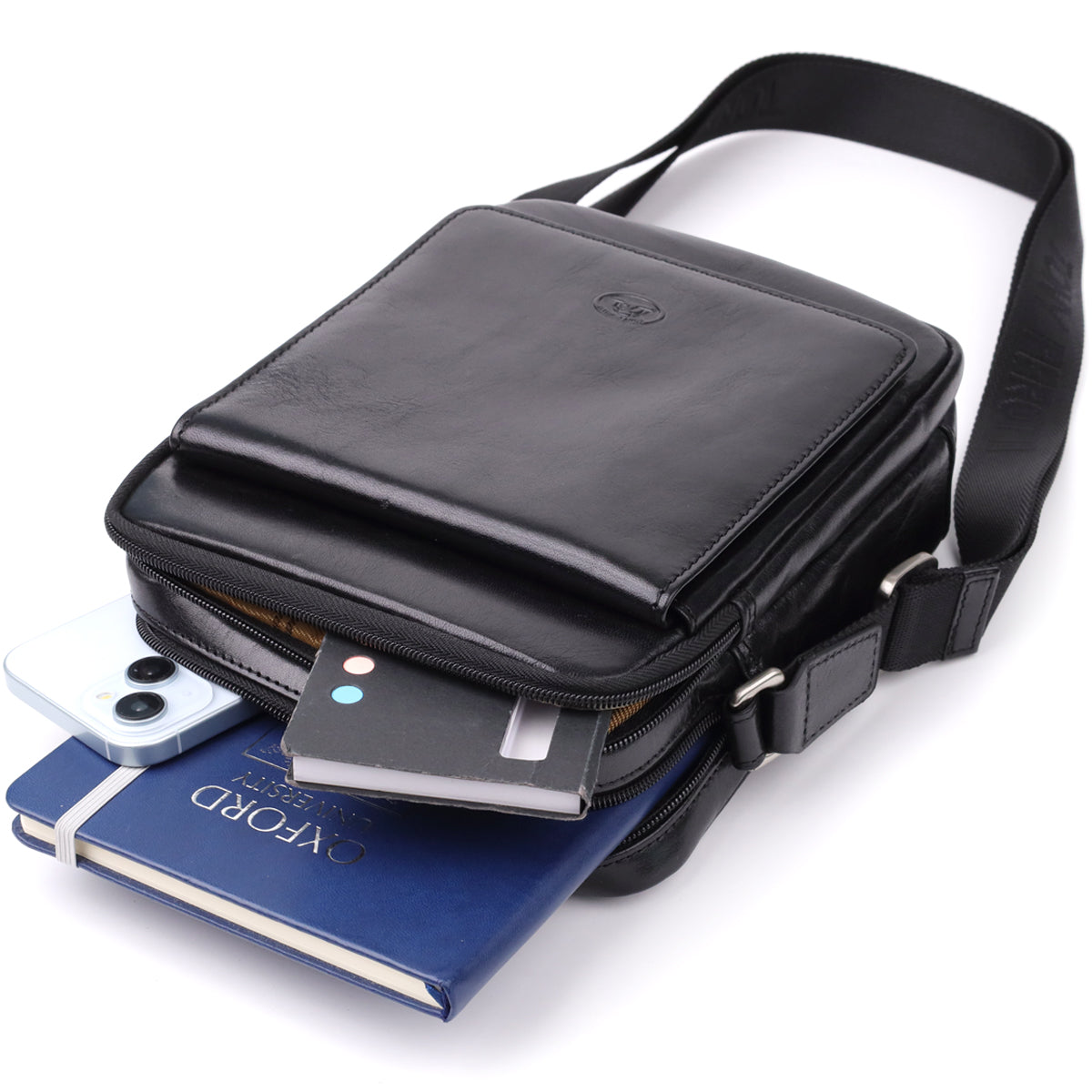 Italico 9148-17 black bag styled with a phone, a notebook and a power bank spilling from the front pocket to show its capacity