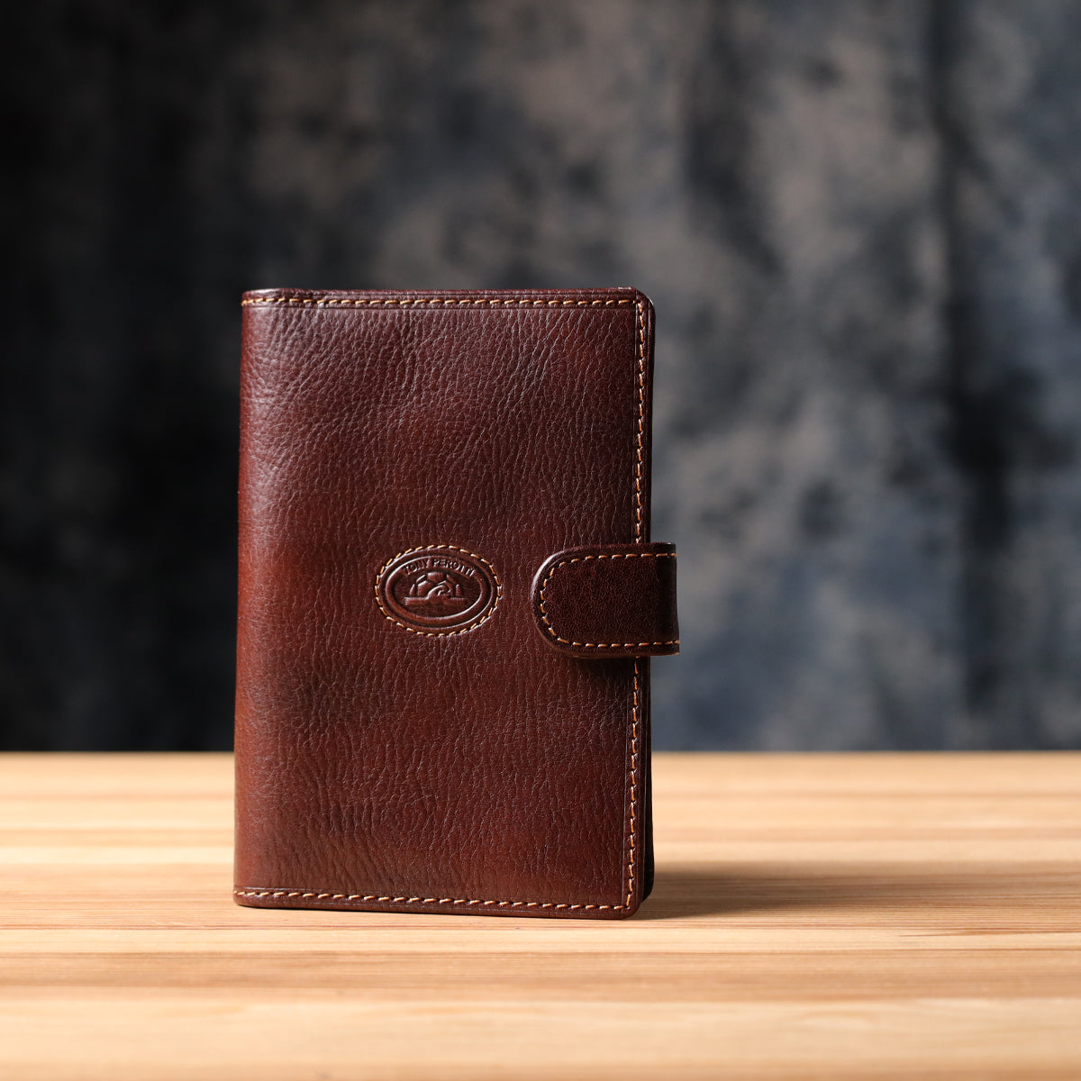 Tony Perotti Italico 1423A moro document holder standing closed on a wooden surface against a dark textured background