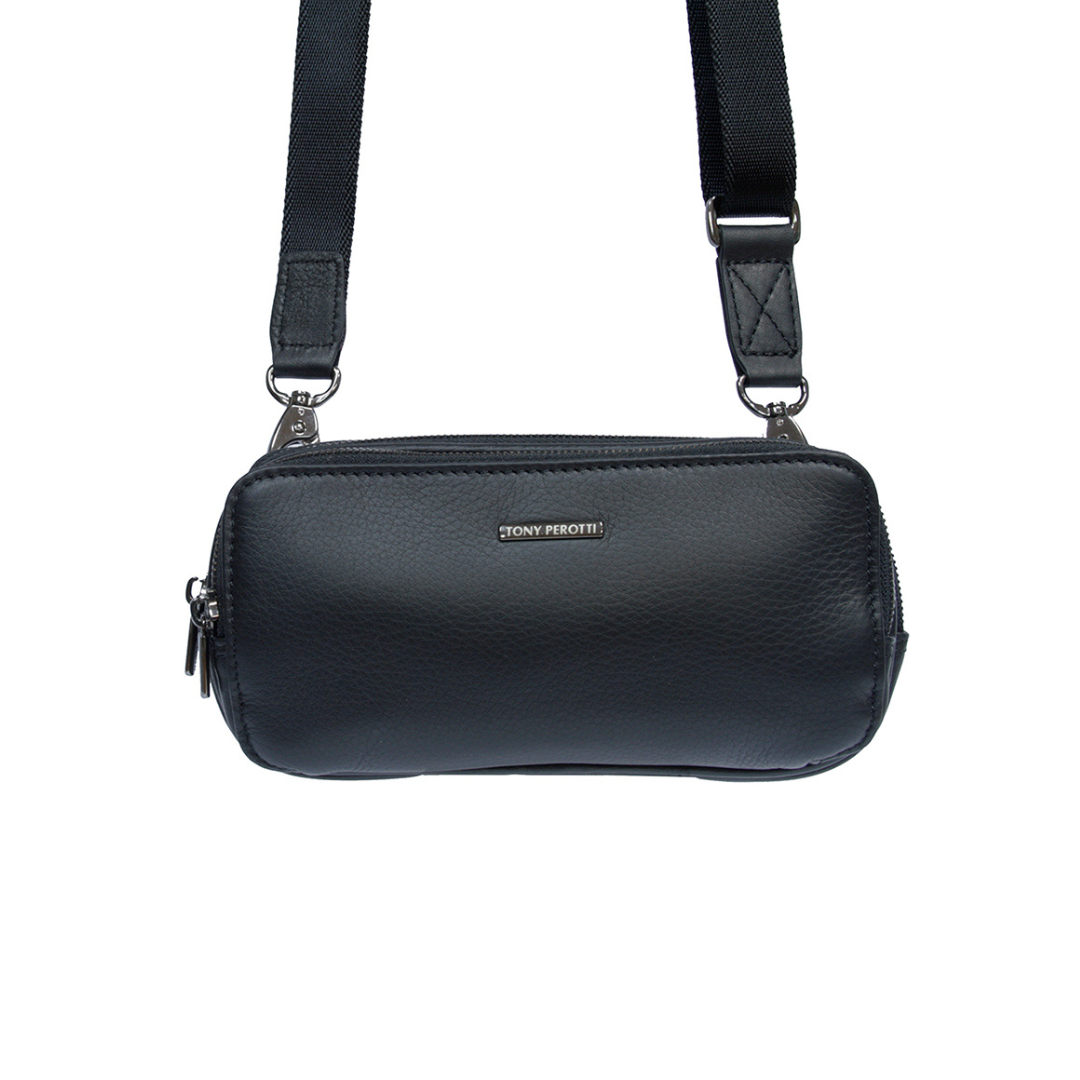 Black leather clutch worn as a crossbody bag with the detachable textile shoulder strap clipped to both D-rings