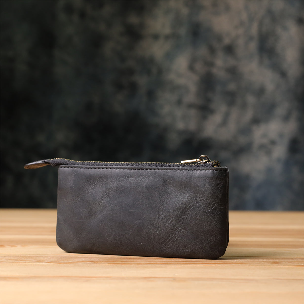 Back of the Tony Perotti Arno 3350 nero key case standing on a wooden surface against a dark textured background