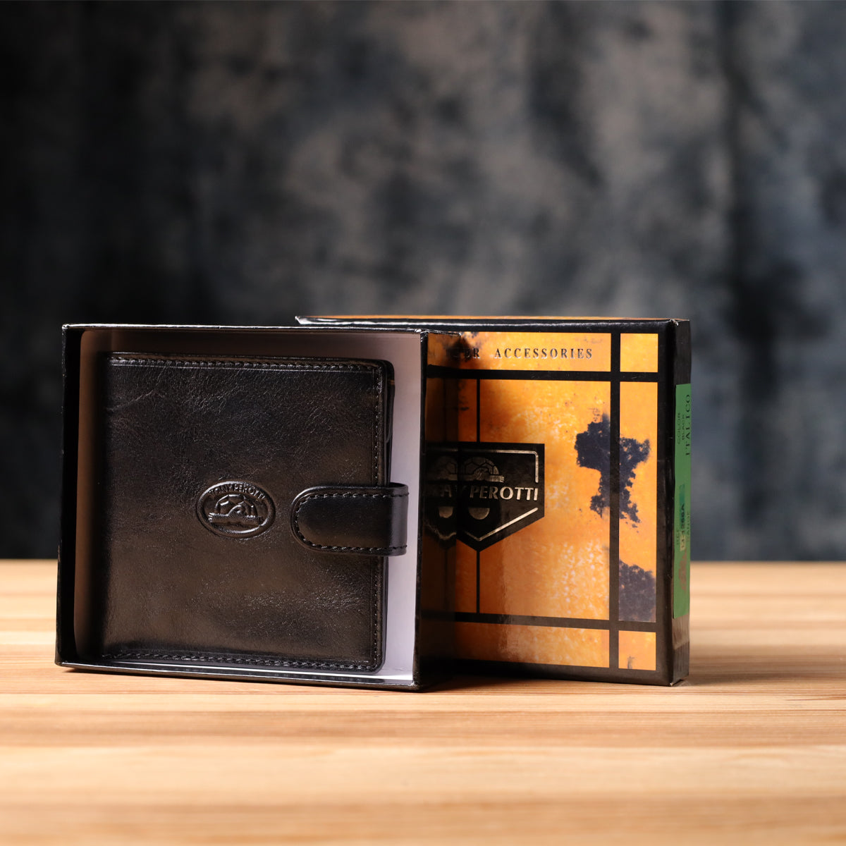Tony Perotti Italico 1256 nero black leather compact wallet standing in its open marbled orange and black printed gift box, green Italico label visible