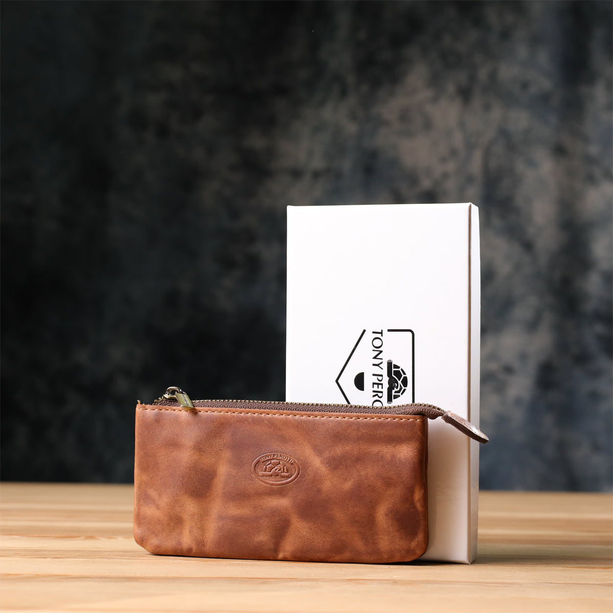 Tony Perotti Arno 3350 whisky key case standing in front of its white Tony Perotti gift box on a wooden surface