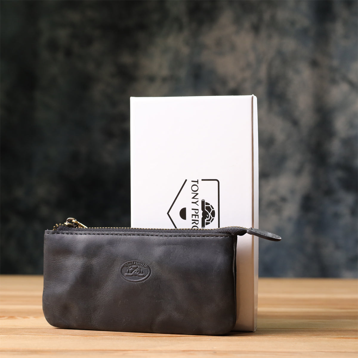Tony Perotti Arno 3350 nero key case standing in front of its white Tony Perotti gift box on a wooden surface