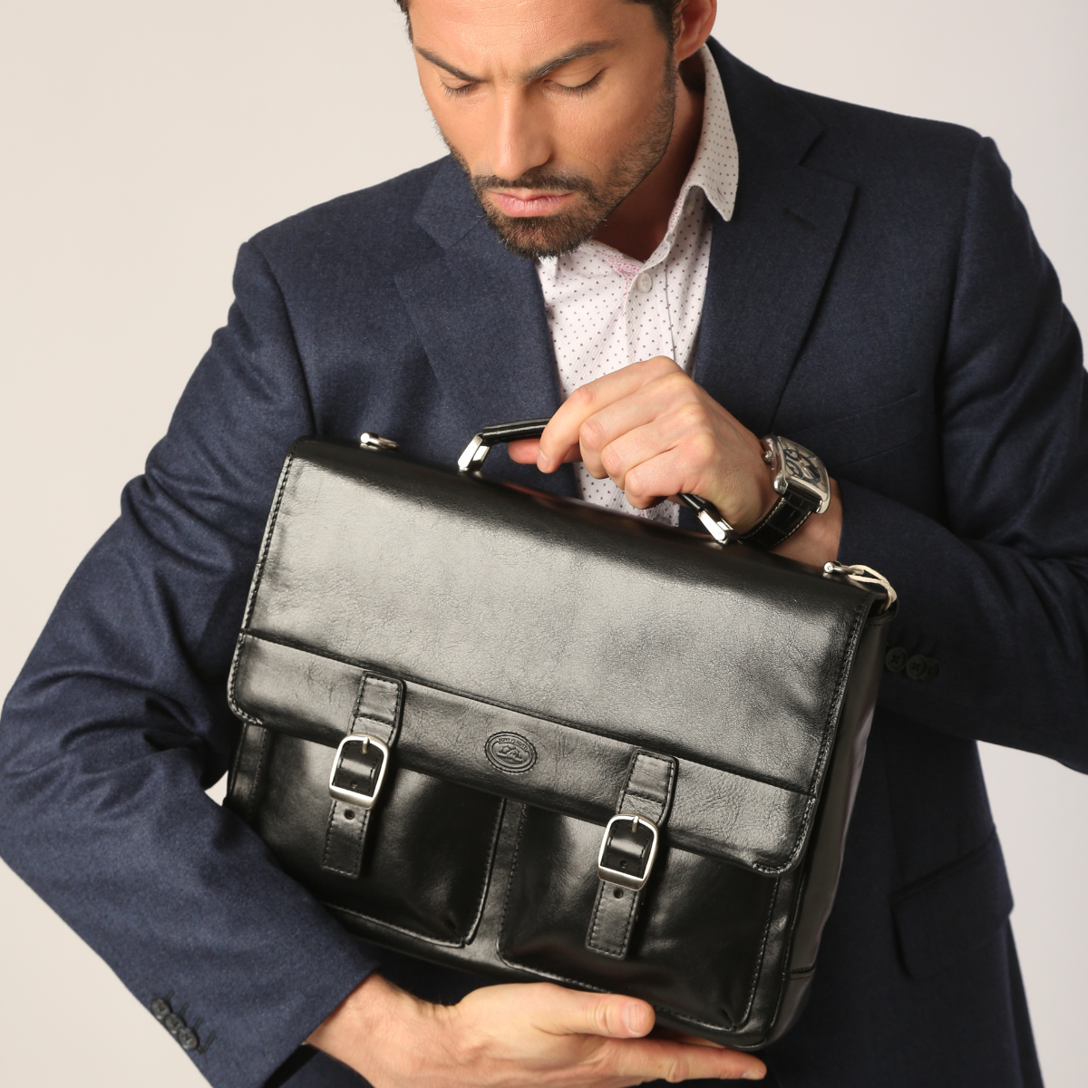 A man holds a black leather briefcase by Tony Perotti
