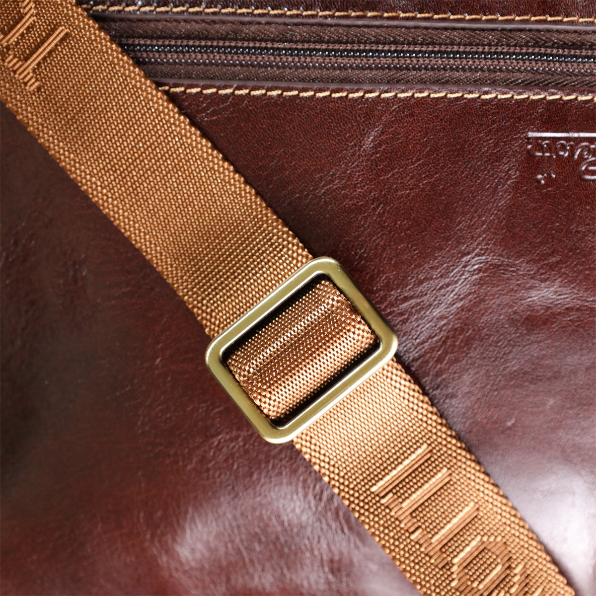 Macro shot of the strap's brass slide buckle on the Italico 9148-17 bag with TONY PEROTTI woven into the webbing