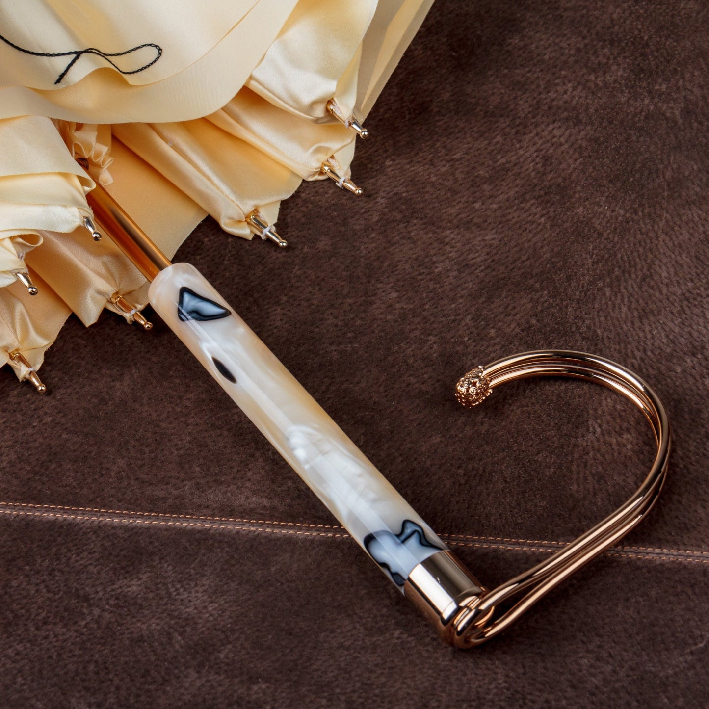 Pasotti umbrella with a decorative handle on a brown surface