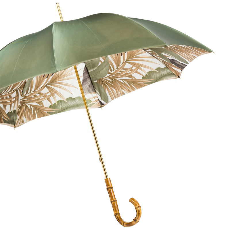 Open sage green umbrella from the side showing the tropical leaf print inside the canopy and gold-tone shaft