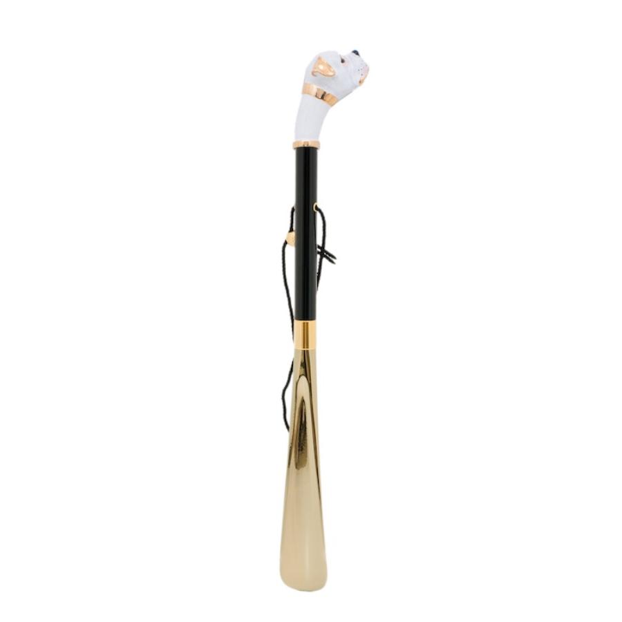 White boxer shoehorn standing upright: glossy black shaft, hanging cord and gold-tone blade