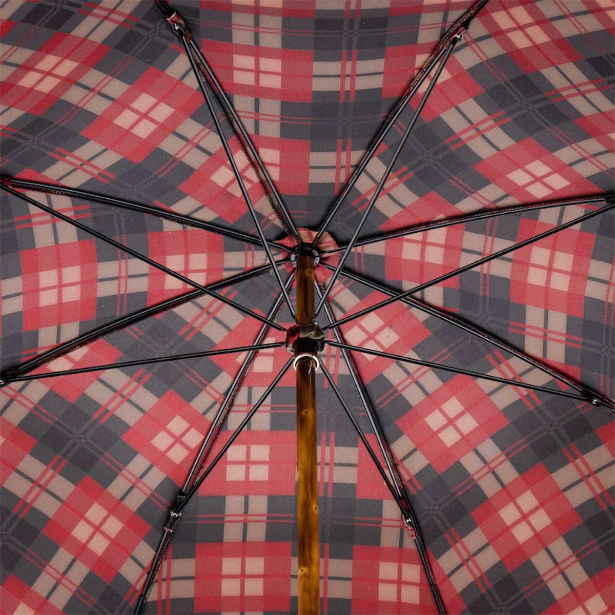 Underside of the tartan canopy: eight ribs and a knotted wooden shaft
