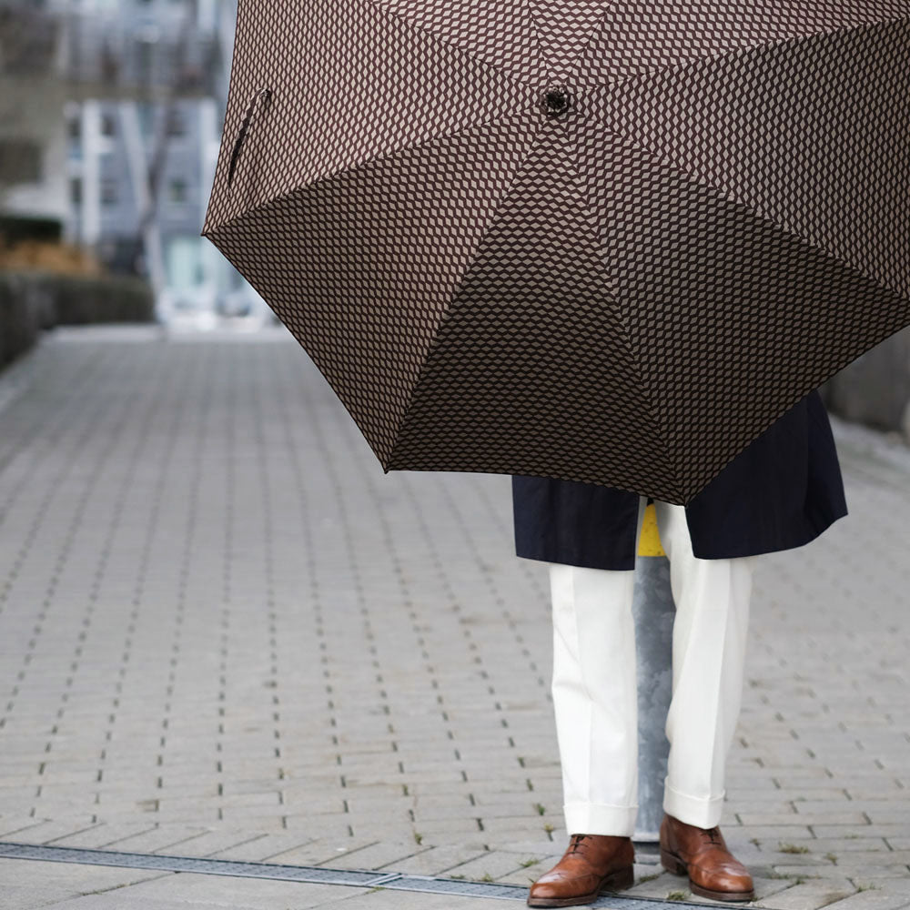 Man standing under the open umbrella, with the jacquard canopy seen from above