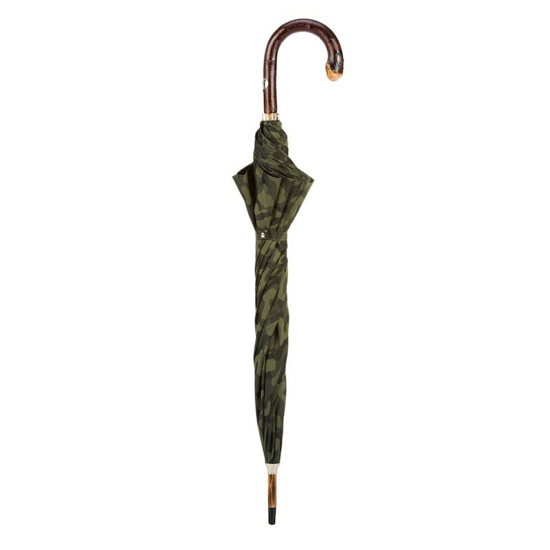 Closed camouflage umbrella standing upright with chestnut crook handle
