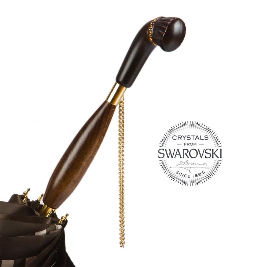 Wooden handle with a band of amber-toned crystals, gold-tone collar and chain, close-up, handcrafted in Italy