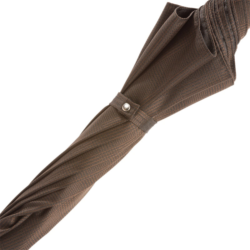 Fabric strap with silver-tone snap button on the furled brown check canopy