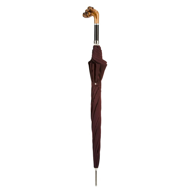 Closed burgundy umbrella standing upright with wooden bulldog head handle