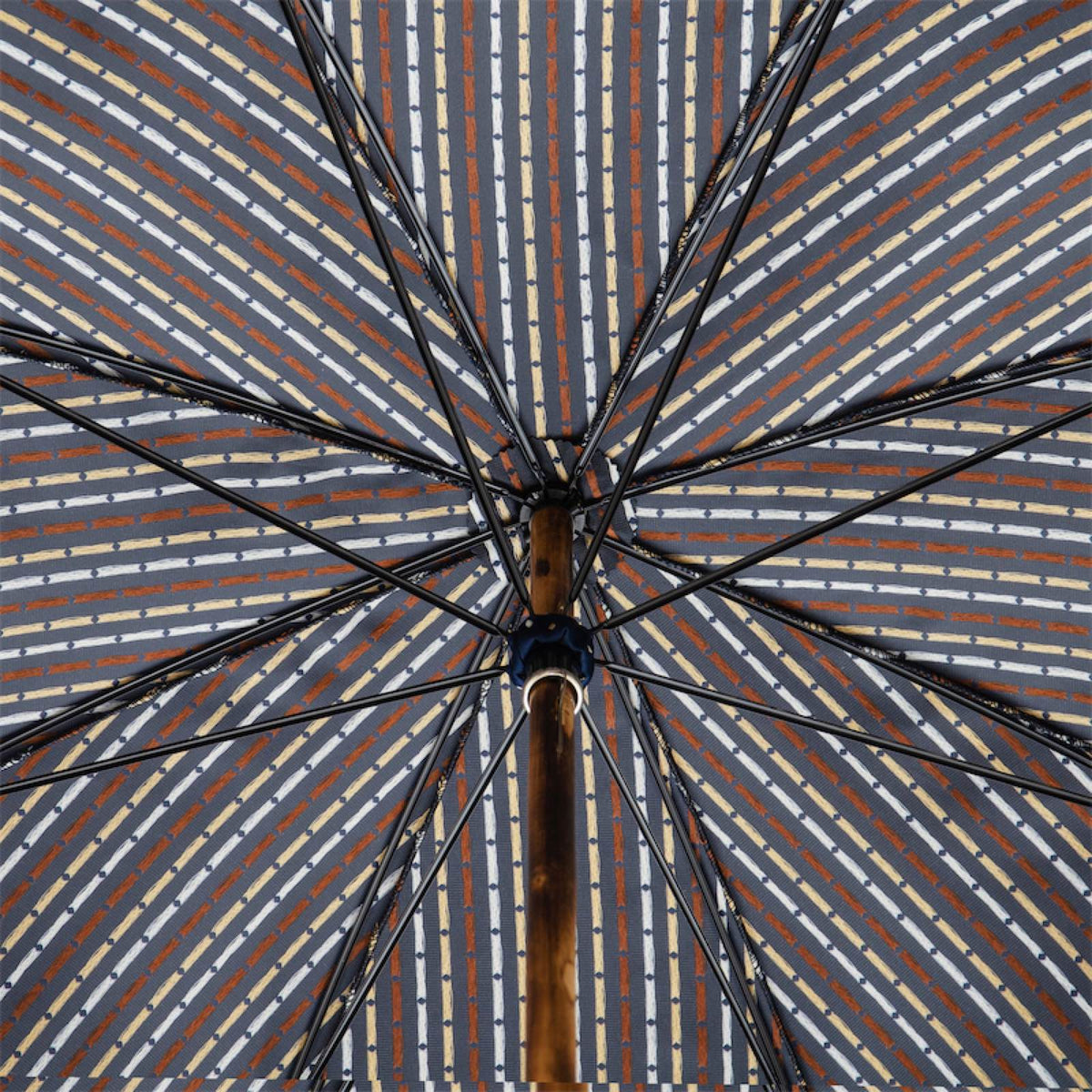 Underside of the canopy with dashed stripes in white, beige and rust, ribs and chestnut shaft