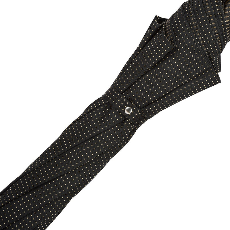 Furled black pin-dot canopy held by the fabric strap