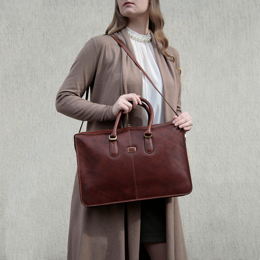 Woman carrying the cognac leather briefcase Tony Perotti Italico 8098 cognac on the shoulder strap
