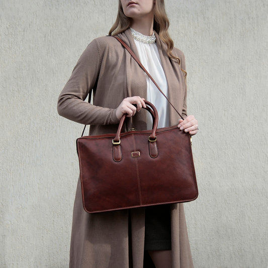 Woman carrying the cognac leather briefcase Tony Perotti Italico 8098 cognac on the shoulder strap