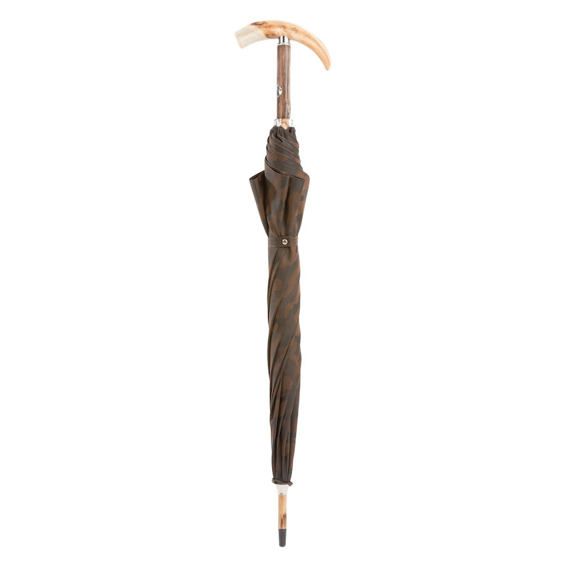 Closed brown camouflage umbrella standing upright with tusk handle and wooden tip