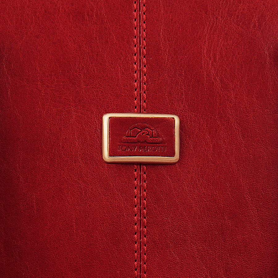 Close-up of the metal Tony Perotti plate set into the front seam of the red Italico 8149 leather bag