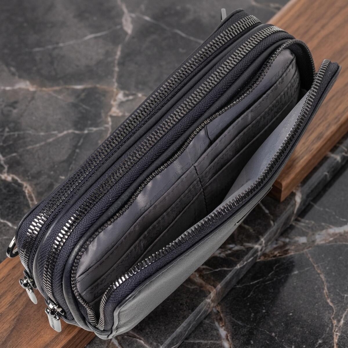 Open navy Tony Perotti clutch — three zip compartments with leather card slots inside