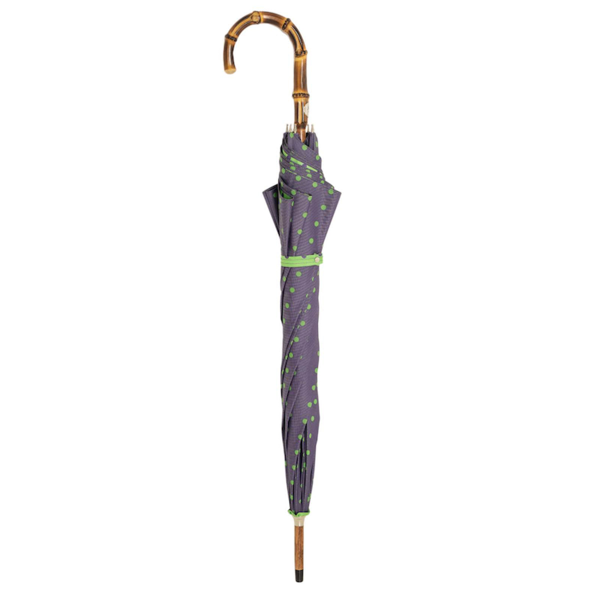 Closed purple umbrella with green dots standing upright, bamboo crook handle