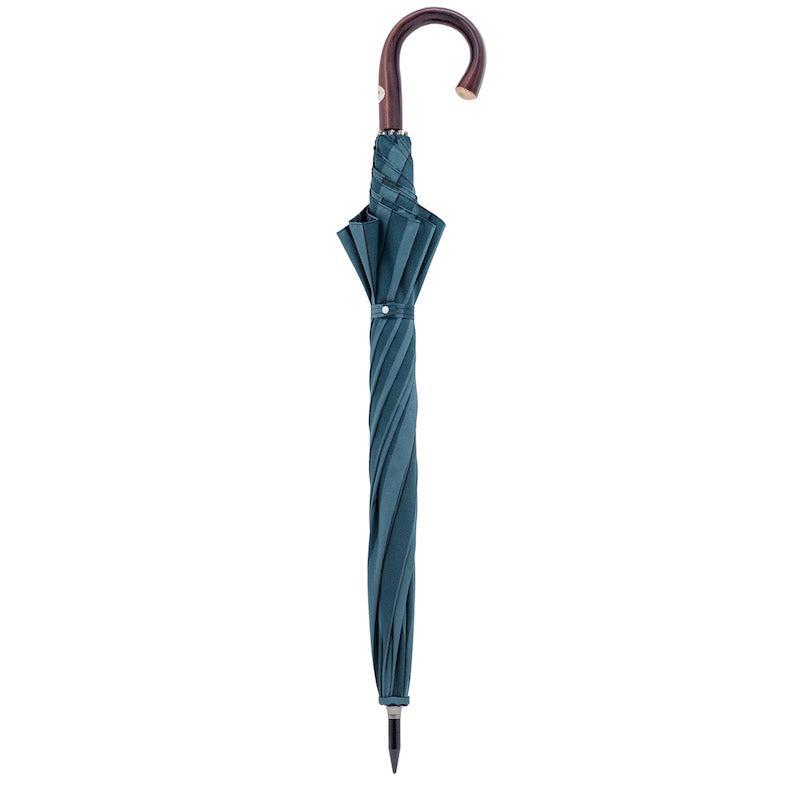 Closed teal blue umbrella standing upright with the dark chestnut handle