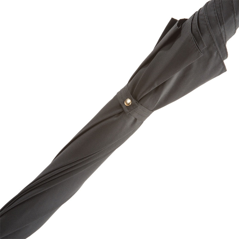 Furled canopy close-up: fine textured black fabric and strap with gold-tone snap button