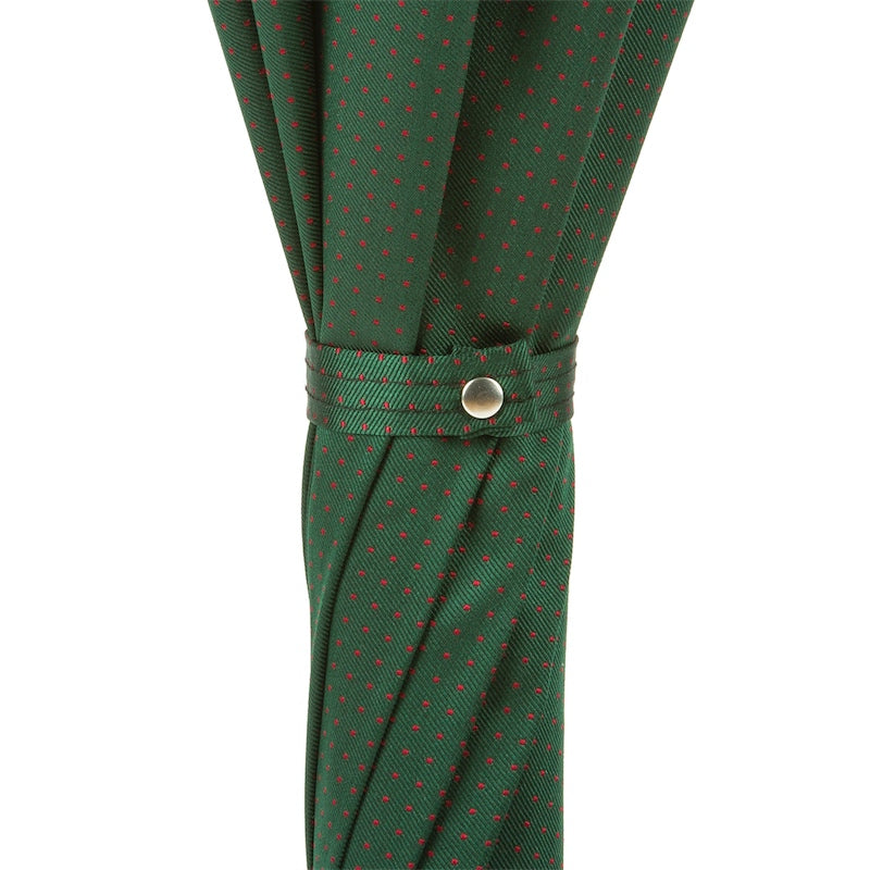 Fabric strap with snap button on the furled green canopy with tiny red dots