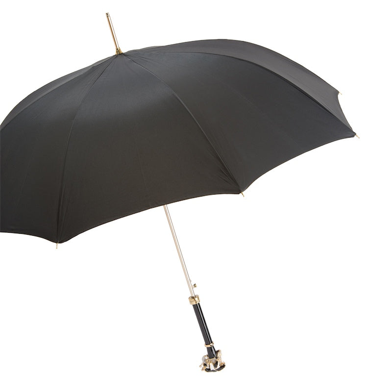 Open black umbrella from the side with gold-tone shaft and jester skull handle