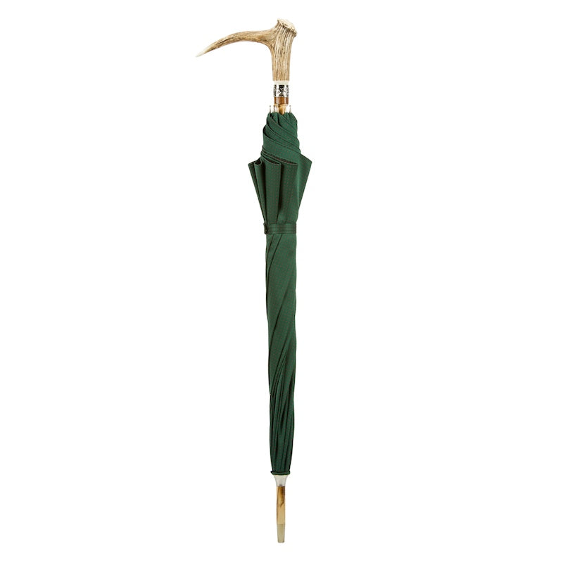Closed green umbrella standing upright with deer antler handle and natural wood shaft