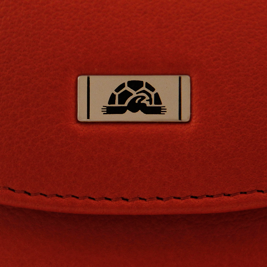 Tony Perotti Contatto 1703 rosso — close-up of the silver-tone metal plate with the Tony Perotti turtle