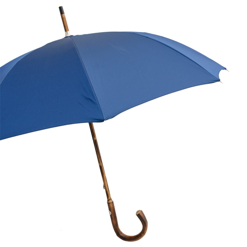 Open blue umbrella from the side with the solid chestnut shaft and crook handle