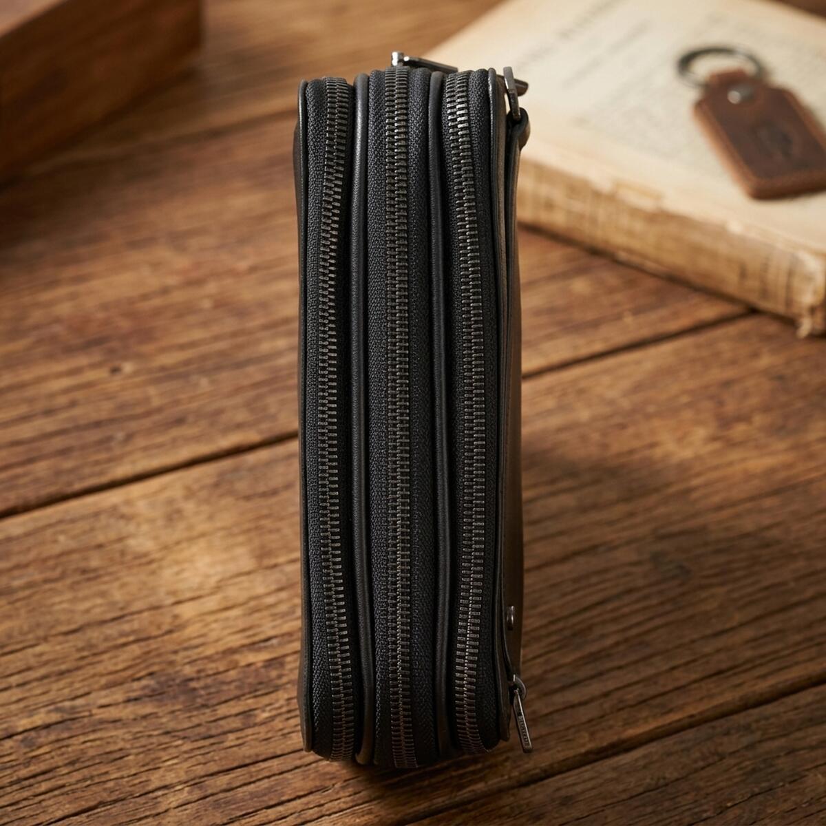Side of the black Tony Perotti New Contatto 6168 clutch — three separate zips running along the top