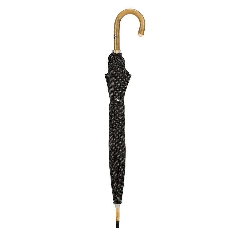 Closed black umbrella standing upright with ash crook handle