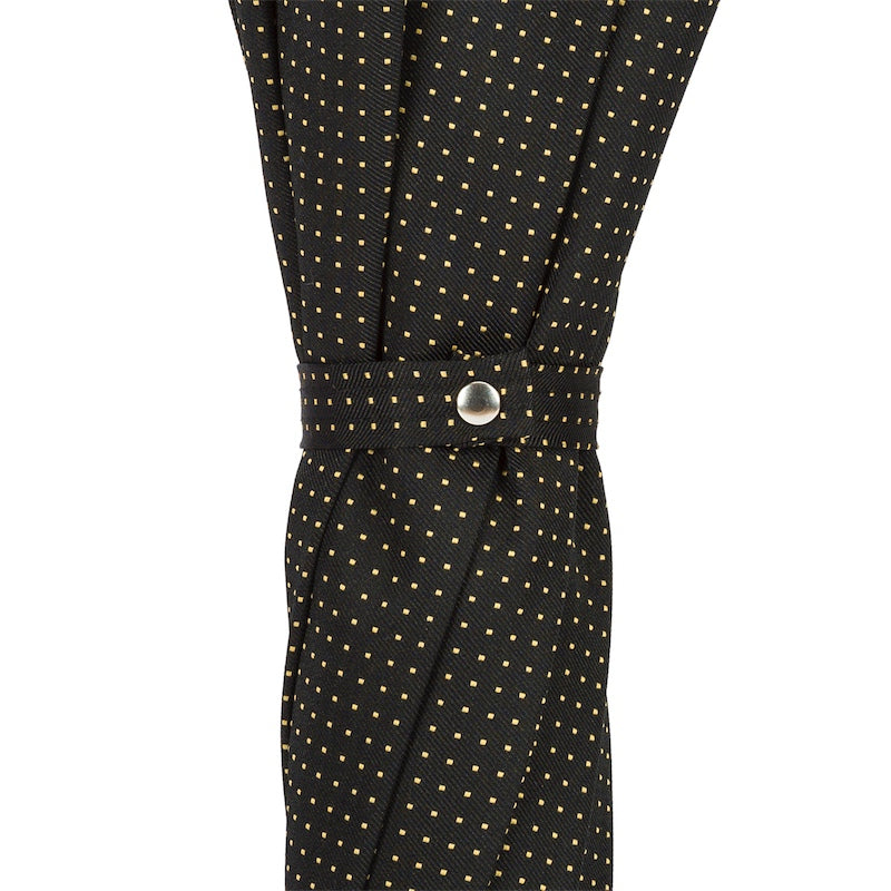 Fabric strap with silver-tone snap button on the furled black canopy with gold pin-dots