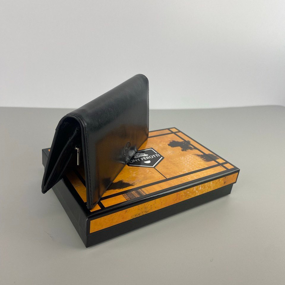 Tony Perotti Italico 2770 nero black leather flap wallet standing half open on top of the printed Tony Perotti gift box, grey background